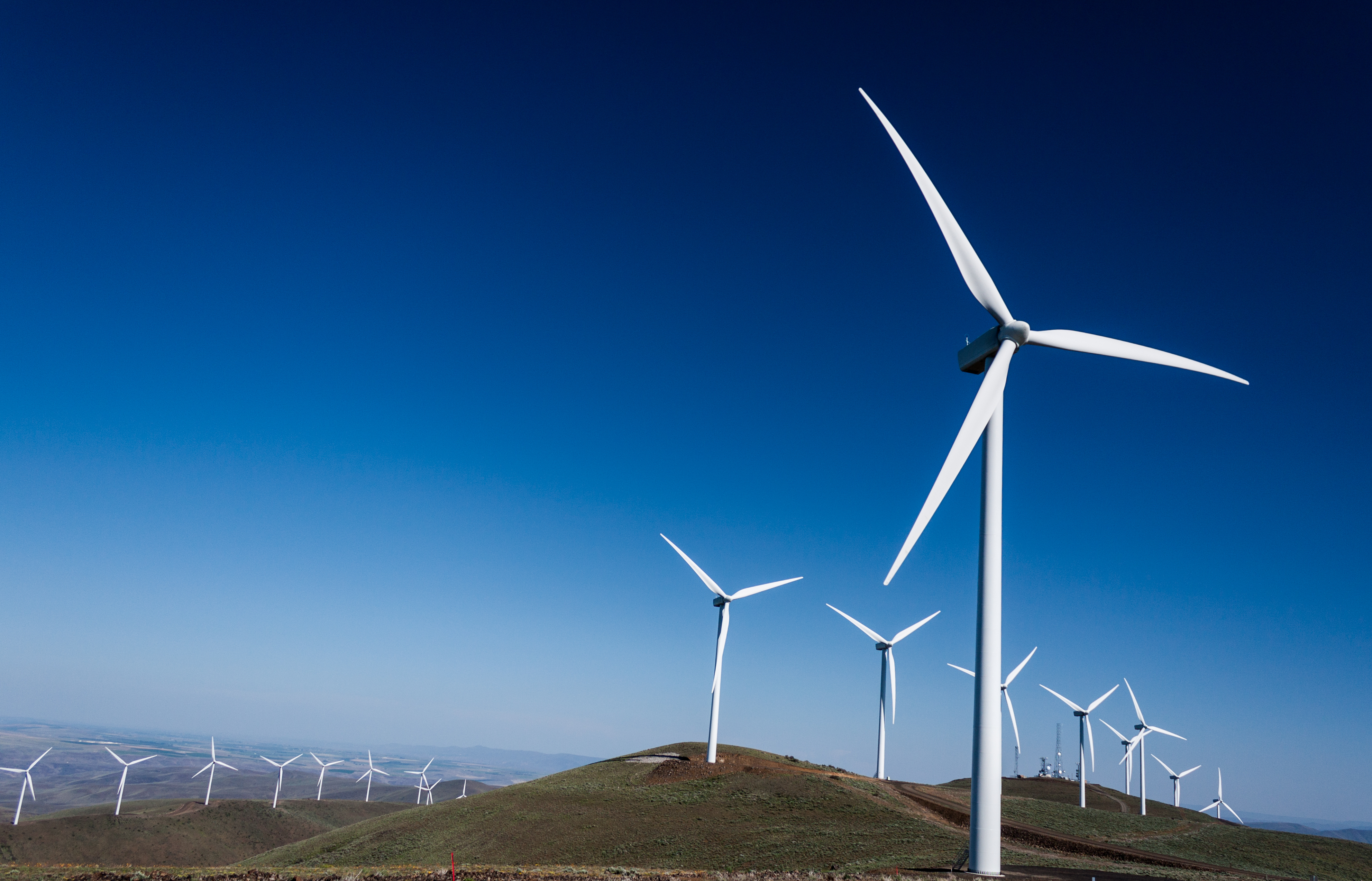 Power turbine wind mills on rolling hills with a blue sky Power turbine wind mills on rolling hills with a blue sky