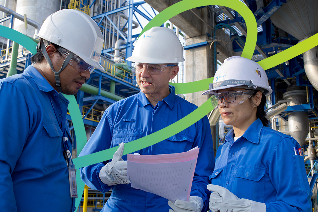 three-workers-with-helmets-and-work-gear-talking three-workers-with-helmets-and-work-gear-talking