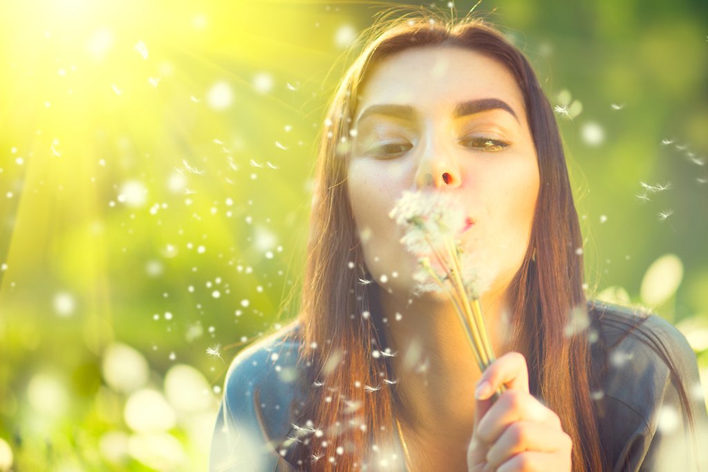 Girl blowing dandelion