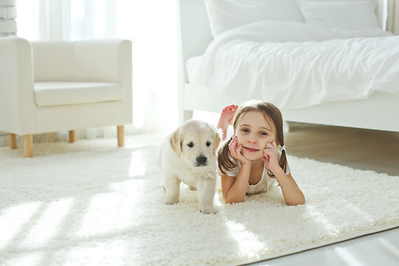 The child with the dog lying on the mat at home