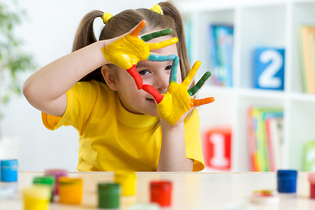cute kid girl have fun painting her hands